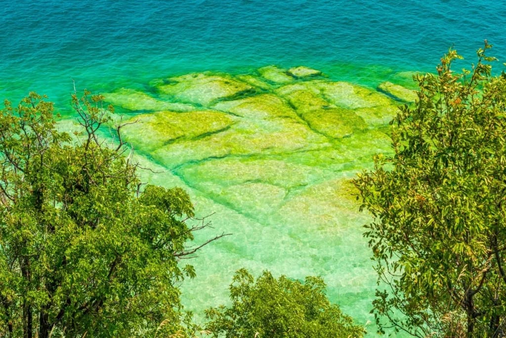 Lastre di roccia chiara e acqua trasparente alla Spiaggia Giamaica di Sirmione